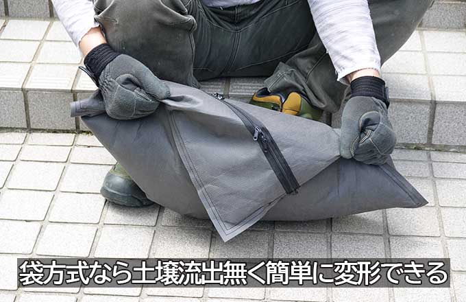 袋方式の緑化ユニットを手で折り曲げ、土壌がこぼれない状態で変形できることを示している写真。