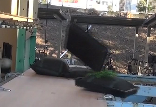 強風下で屋上緑化トレーが浮き上がり、揚力により飛散している瞬間の様子